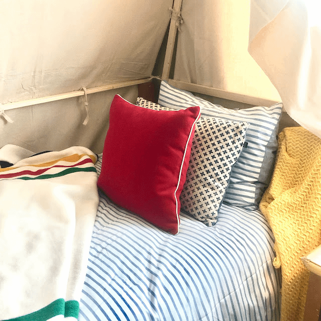 This outdoorsy bedroom has a comfy bed with lots of colourful pillows